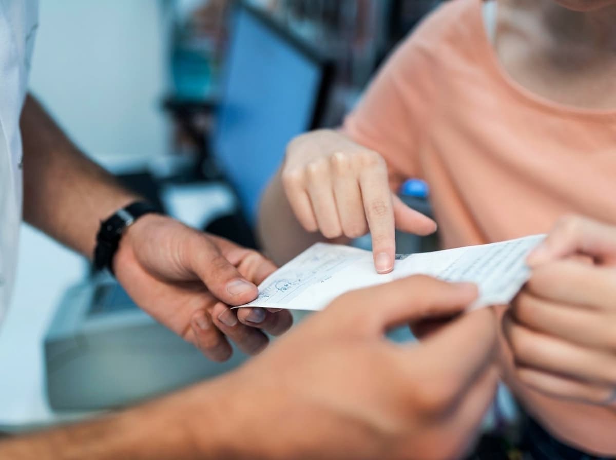 Patient checking in at the Village Pharmacy pickup counter